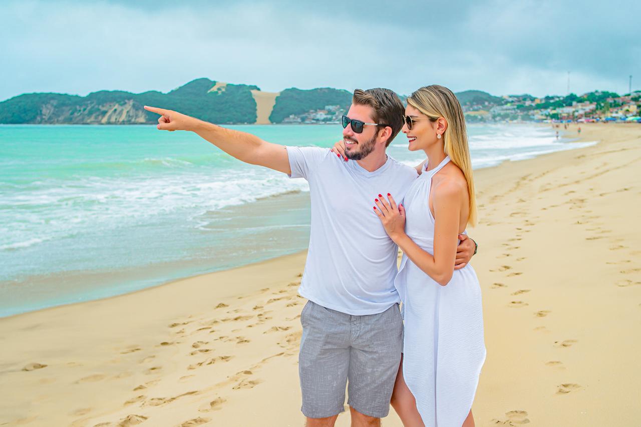 Gustavo e Caroline abraçados na praia, olhando o horizonte